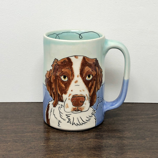 Mug with a dog illustration on a white and wooden surface