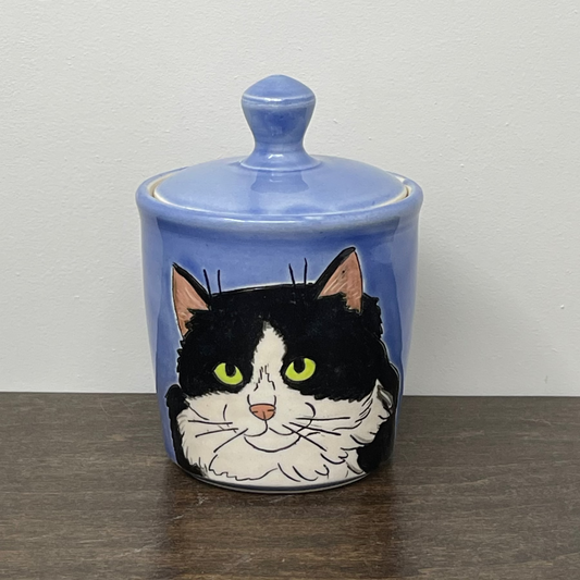 Ceramic jar with a cat illustration on a blue background
